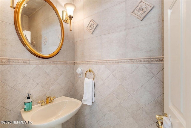 bathroom with sink and tile walls