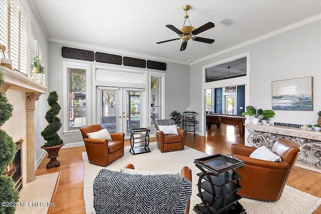 living room featuring ornamental molding, a textured ceiling, and a high end fireplace