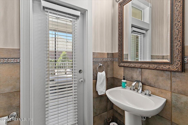 bathroom featuring sink and tile walls