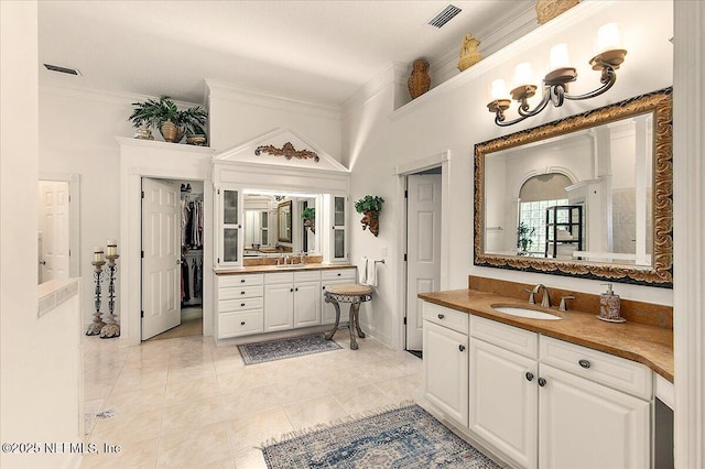 bathroom featuring tile patterned flooring, vanity, and ornamental molding