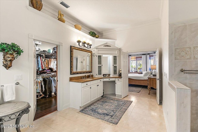 bathroom featuring vanity, tile patterned floors, and crown molding