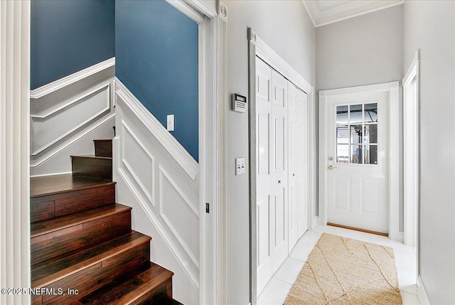 stairs featuring tile patterned floors and ornamental molding