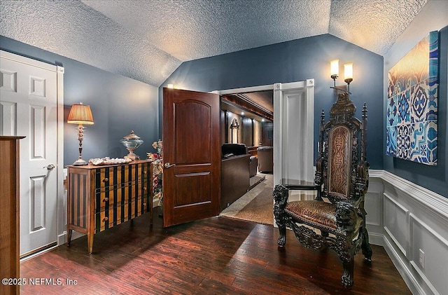 interior space featuring a textured ceiling, dark hardwood / wood-style flooring, and lofted ceiling