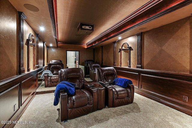 home theater featuring carpet floors, crown molding, and wooden walls