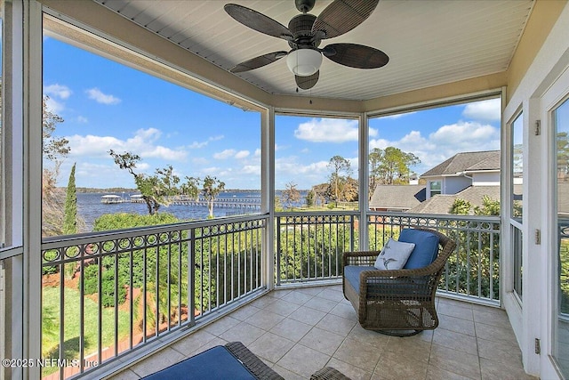 sunroom / solarium featuring a water view and ceiling fan