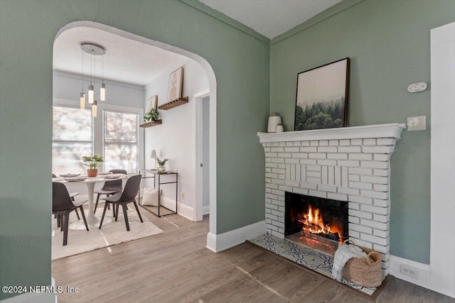 interior space with hardwood / wood-style floors, a textured ceiling, and a brick fireplace