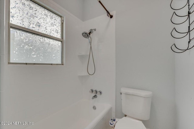 bathroom with tiled shower / bath combo and toilet