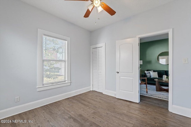 bedroom with a closet, ceiling fan, and dark hardwood / wood-style flooring