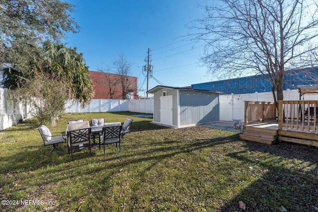 view of yard with a wooden deck, an outdoor living space, and a storage unit