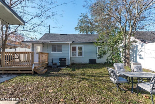 rear view of property featuring a yard, cooling unit, and a deck