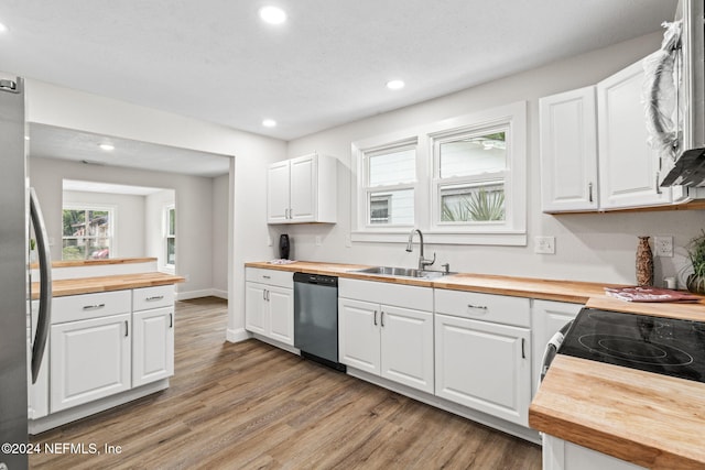 kitchen featuring wooden counters, stainless steel appliances, sink, light hardwood / wood-style flooring, and white cabinetry