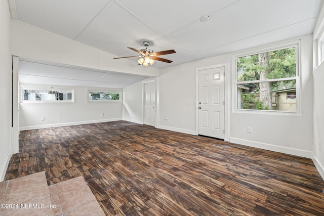 unfurnished living room with ceiling fan and dark wood-type flooring