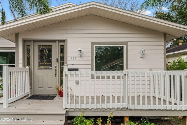 view of exterior entry with a wooden deck