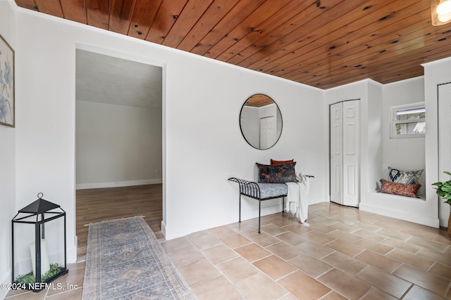 entrance foyer featuring crown molding and wood ceiling