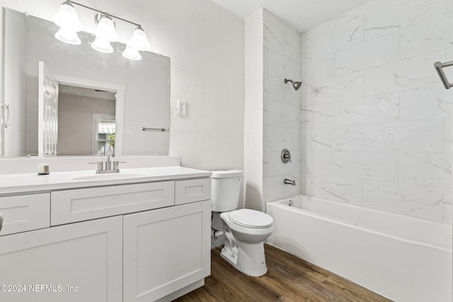 full bathroom with hardwood / wood-style flooring, tiled shower / bath combo, toilet, and vanity