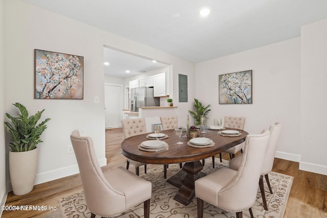 dining area with light hardwood / wood-style floors and electric panel