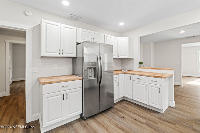 kitchen featuring wooden counters, stainless steel fridge with ice dispenser, kitchen peninsula, and white cabinetry