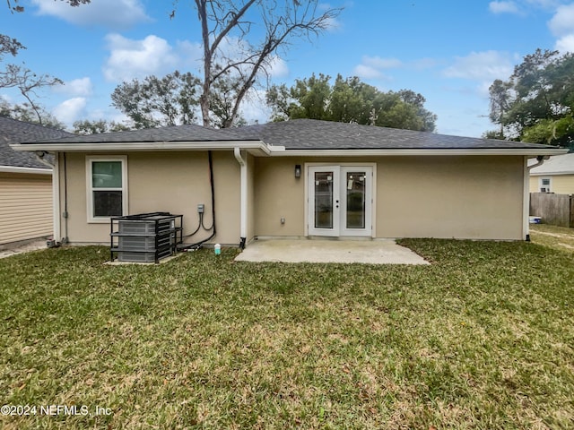 back of property with a lawn and a patio area