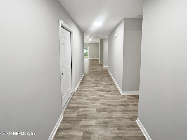 corridor with light hardwood / wood-style floors