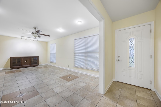 foyer featuring track lighting, light tile patterned flooring, baseboards, and ceiling fan