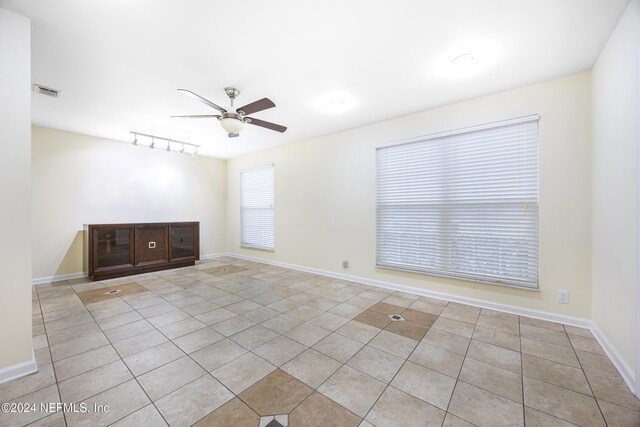 tiled spare room featuring ceiling fan