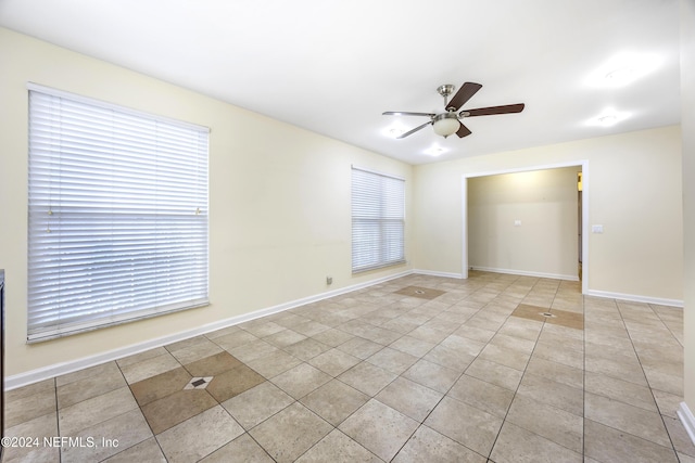 tiled spare room featuring ceiling fan