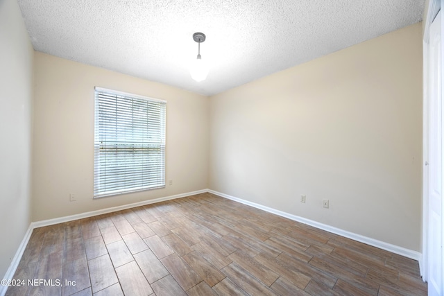 unfurnished room with a textured ceiling