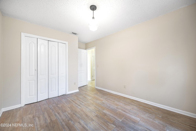 unfurnished bedroom featuring a textured ceiling and a closet