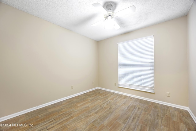 empty room with a textured ceiling, light hardwood / wood-style flooring, and ceiling fan