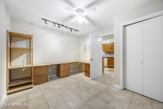 interior space featuring ceiling fan, rail lighting, and built in desk