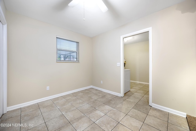 tiled spare room featuring ceiling fan