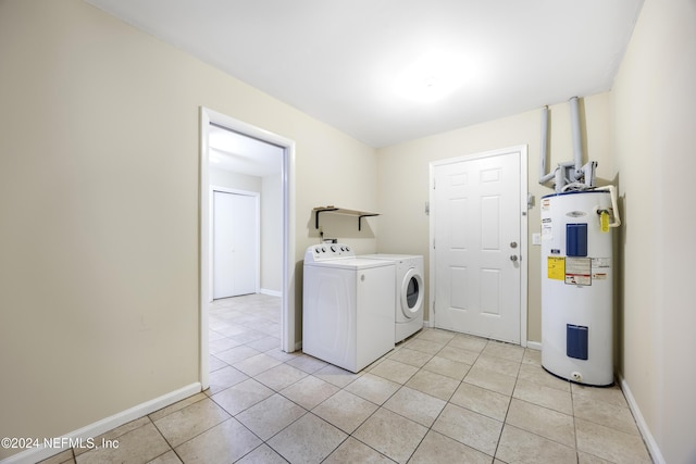 laundry area with washing machine and clothes dryer, electric water heater, and light tile patterned flooring