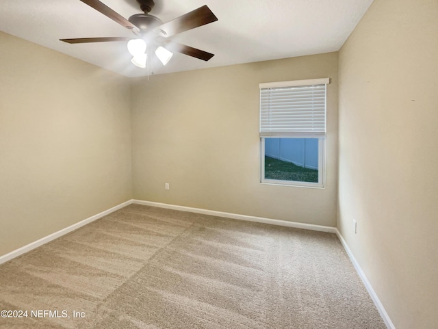 spare room with ceiling fan and light colored carpet