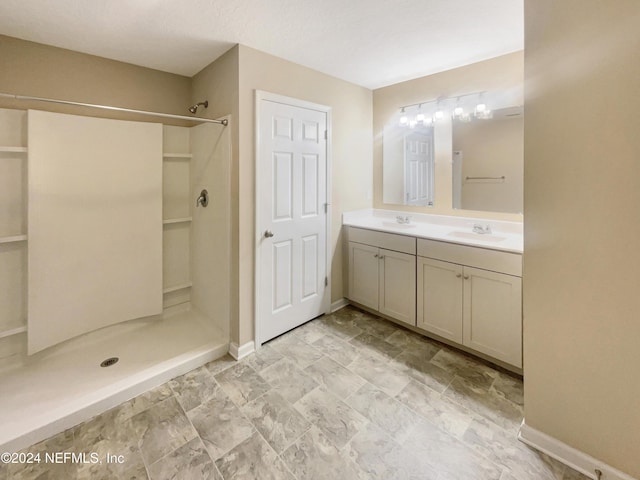 bathroom featuring a textured ceiling, vanity, and walk in shower