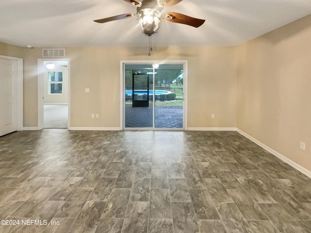 spare room with hardwood / wood-style floors, ceiling fan, and a healthy amount of sunlight