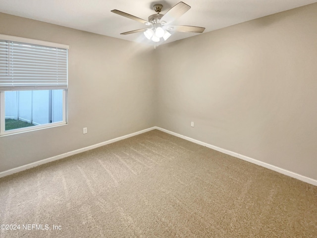 carpeted spare room with ceiling fan