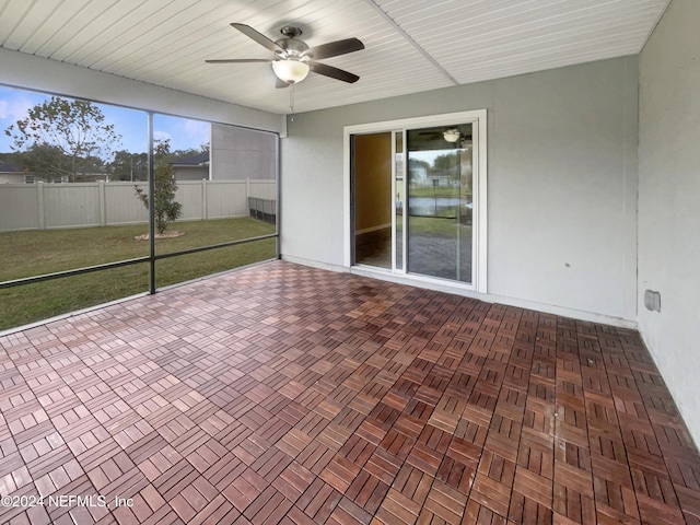 unfurnished sunroom with ceiling fan