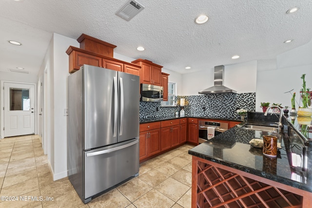 kitchen featuring backsplash, dark stone counters, sink, wall chimney exhaust hood, and stainless steel appliances