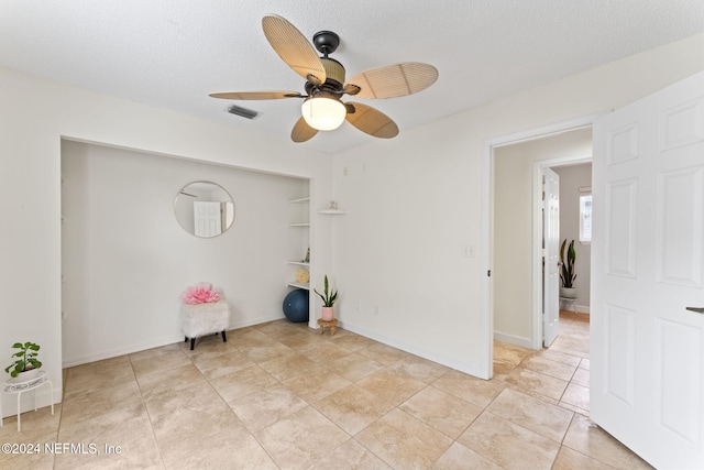 spare room with ceiling fan and a textured ceiling