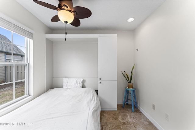 bedroom featuring multiple windows and ceiling fan