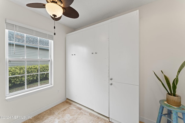 interior space featuring ceiling fan and a closet