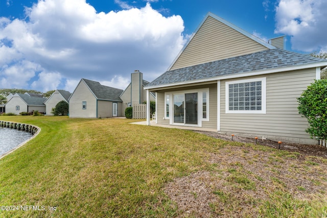 back of house with a yard and a patio