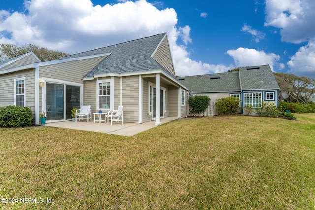 rear view of house featuring a yard and a patio