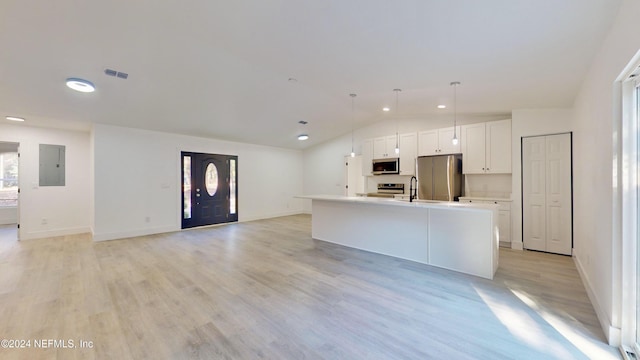 kitchen featuring decorative light fixtures, appliances with stainless steel finishes, electric panel, an island with sink, and white cabinets