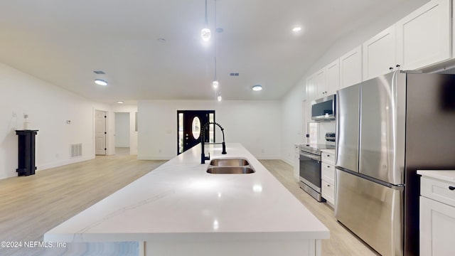 4774 Leopard Cir, Middleburg, FL 32068 - kitchen with appliances with stainless steel finishes, light wood-type flooring, an island with sink, white cabinetry, and recessed lighting