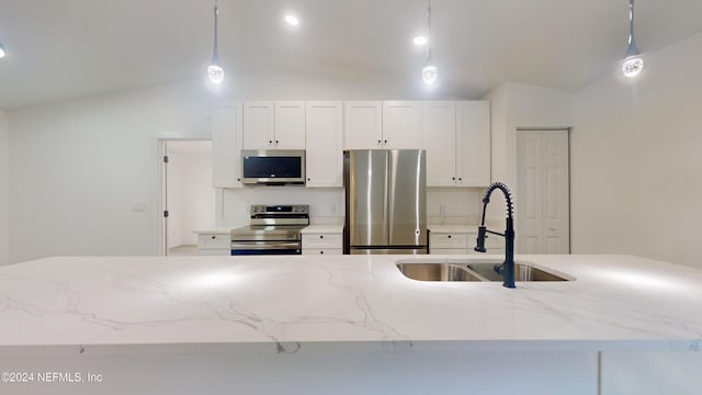 kitchen featuring pendant lighting, stainless steel appliances, vaulted ceiling, and sink