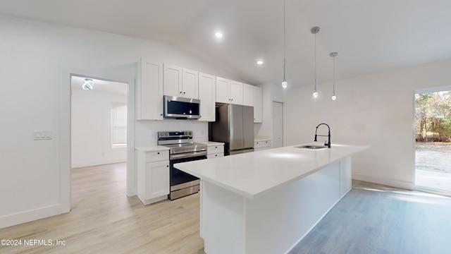 4774 Leopard Cir, Middleburg, FL 32068 - kitchen featuring appliances with stainless steel finishes, light wood finished floors, white cabinets, lofted ceiling, and an island with sink