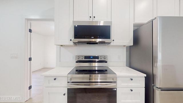 kitchen featuring light stone counters, white cabinets, and appliances with stainless steel finishes