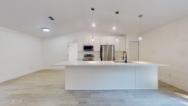 4774 Leopard Cir, Middleburg, FL 32068 - kitchen with appliances with stainless steel finishes, vaulted ceiling, a large island, light countertops, and light wood-type flooring