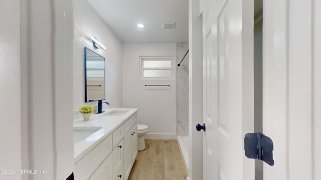 bathroom with vanity, wood-type flooring, toilet, and a shower